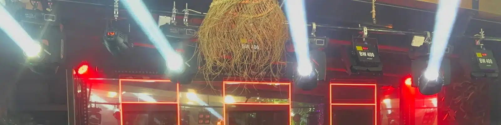 Faisceaux blancs des lyres Beam et encadrements LED rouges pendant le spectacle du restaurant