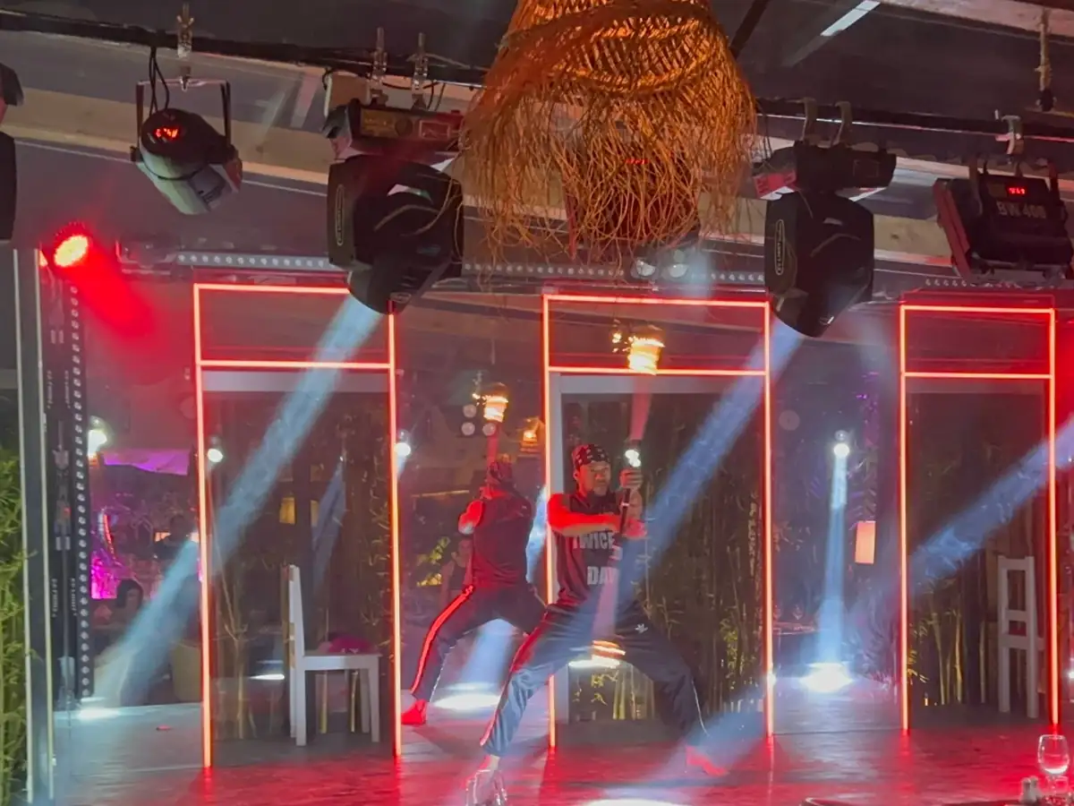 Scène du restaurant Casa Emma éclairée en rouge avec les faisceaux des lyres Beam pendant un numéro de spectacle