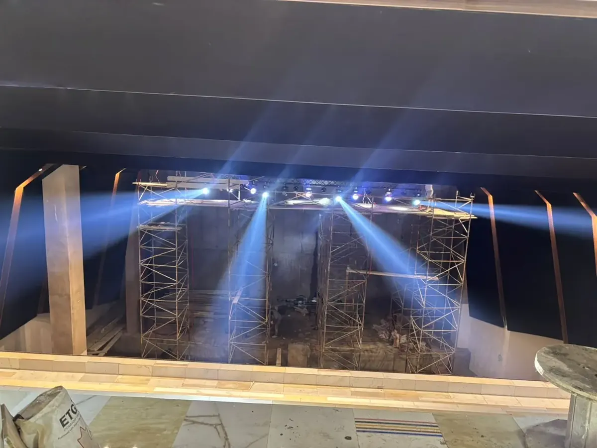 Faisceaux blancs des lyres Beam au-dessus de la scène de l'amphithéâtre en chantier