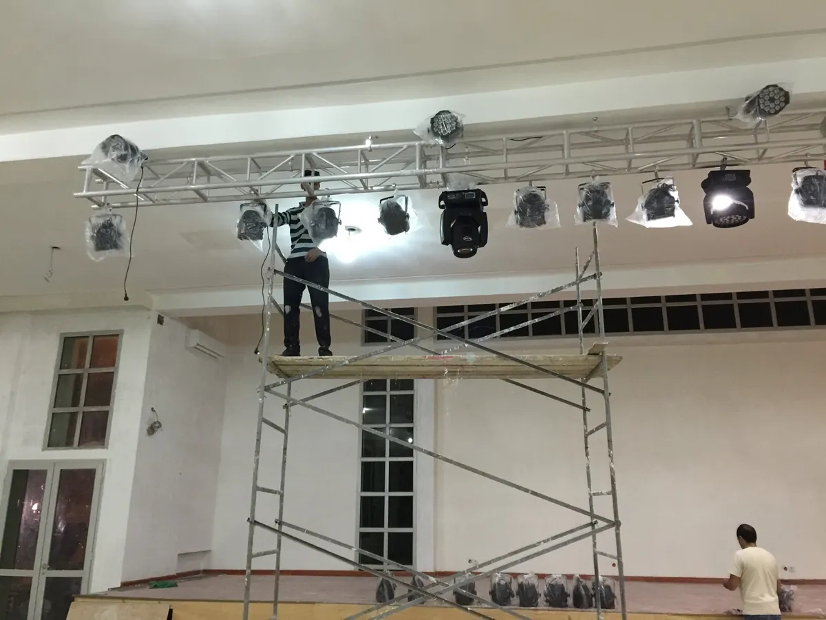 Lyres Beam et projecteurs PAR LED accrochés au pont truss, encore sous film de protection